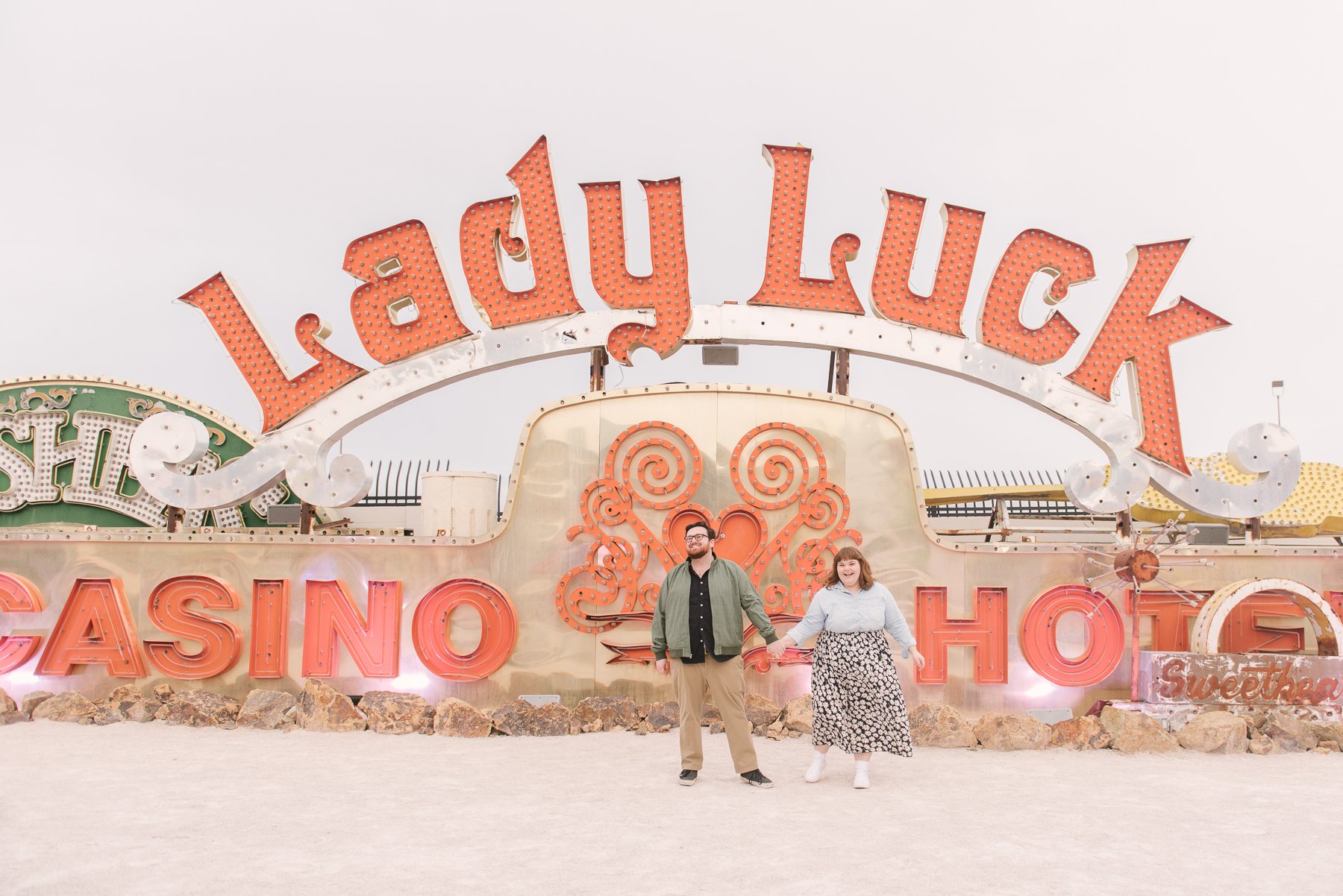 couple in front of lady luck sign