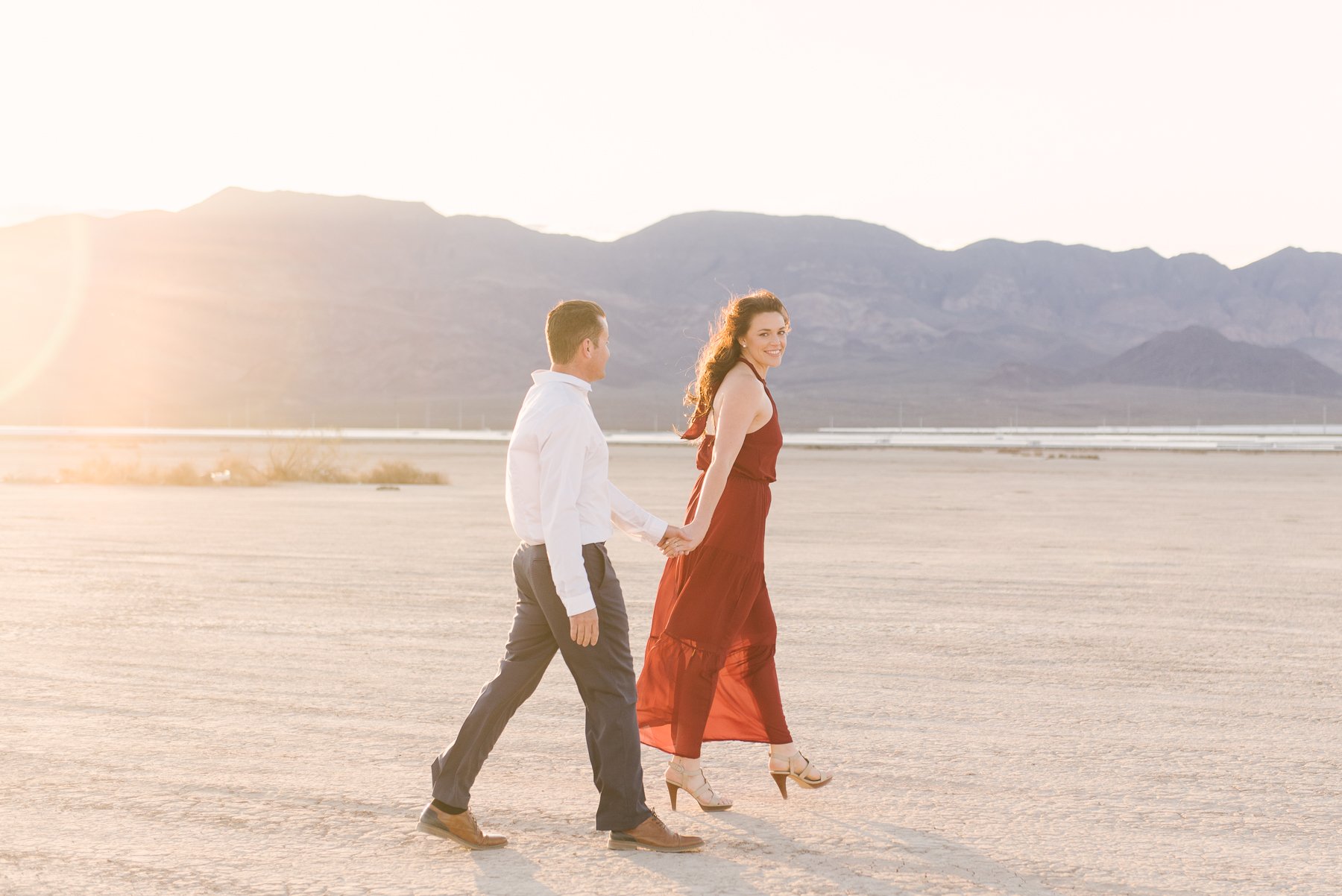 couple walking hand in hand in open desert
