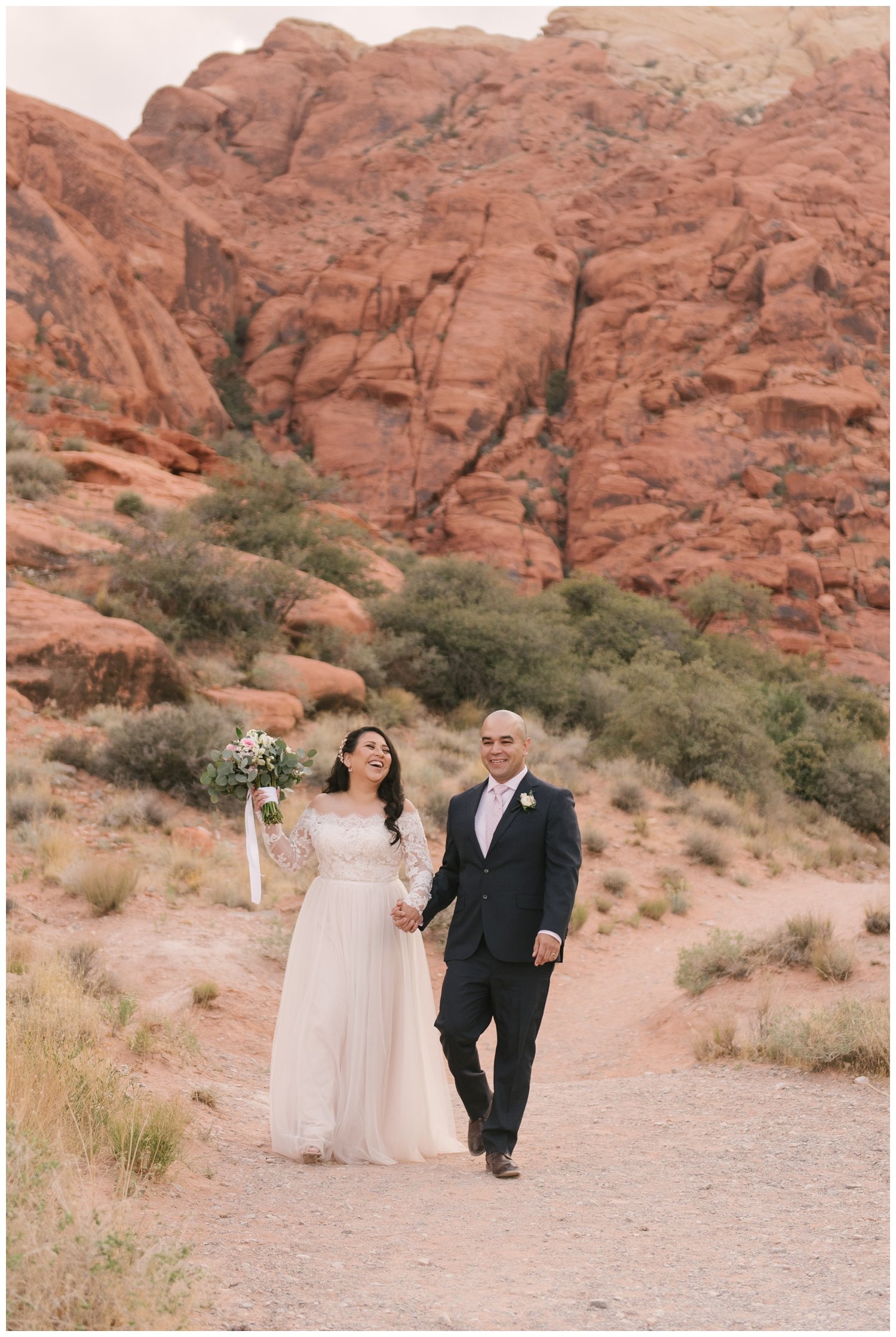 Bride and Groom walking and laughing along red rock canyon