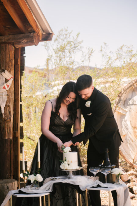 elopement couple cut cake during mini reception in ghost town 