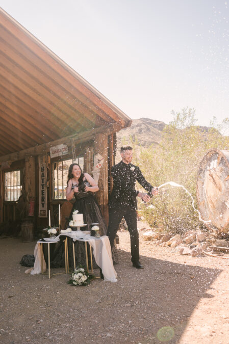 elopement couple have a champagne spray during mini reception in ghost town 