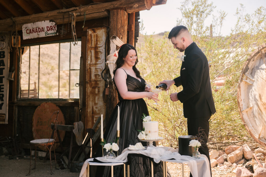 elopement couple have champagne during mini reception in ghost town 