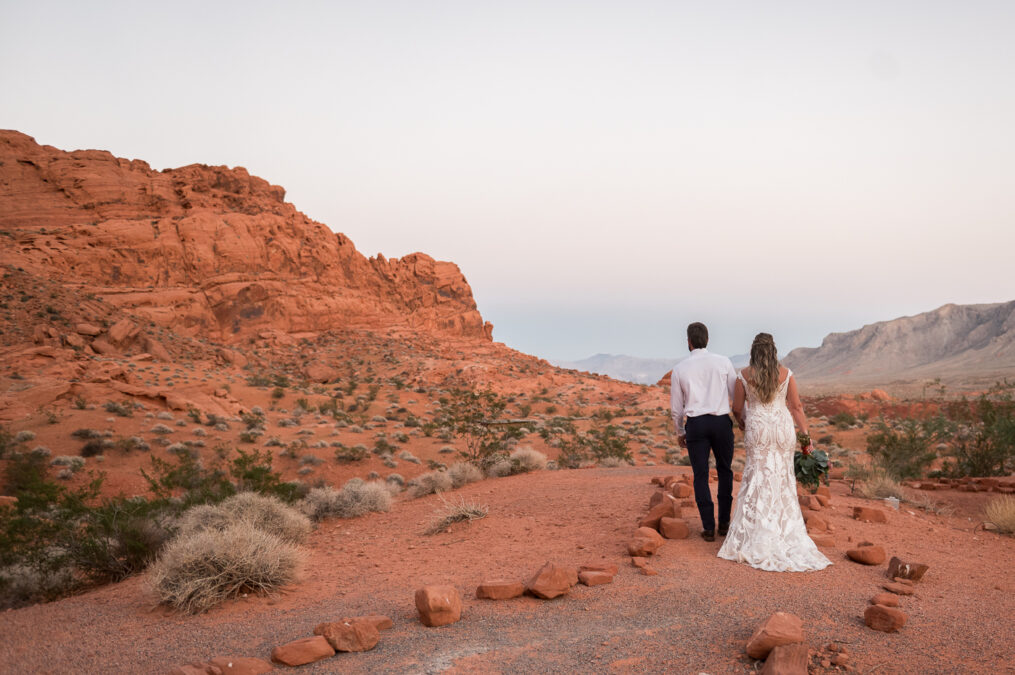 bride and groom waling at valley of fire during sunset wedding