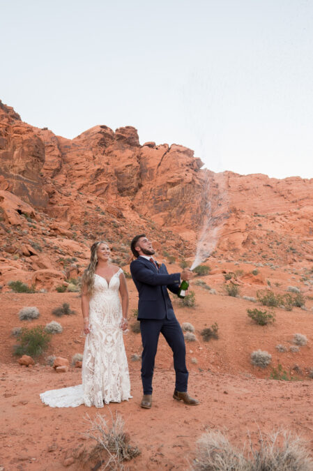 bride and groom celebrating with champagne spray after ceremony