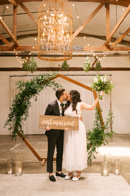 couple kissing and holding just married sign