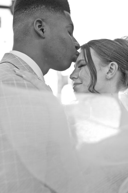 groom kissing bride's forehead