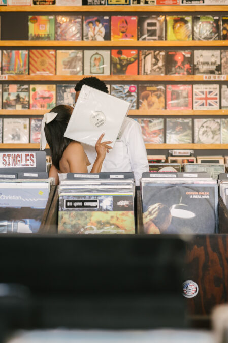 bride and groom kiss behind record in record store downtown las vegas