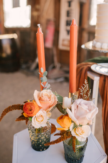 fall details with orange candles and pink and orange roses in vases