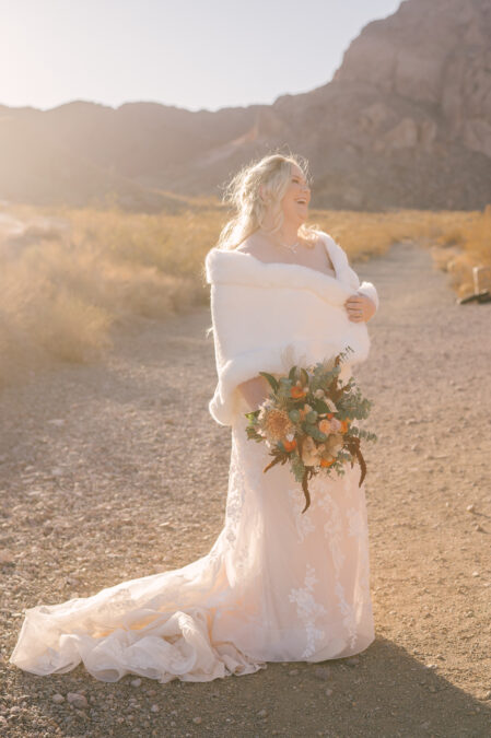 smiling las vegas bride with white faux fur shawl