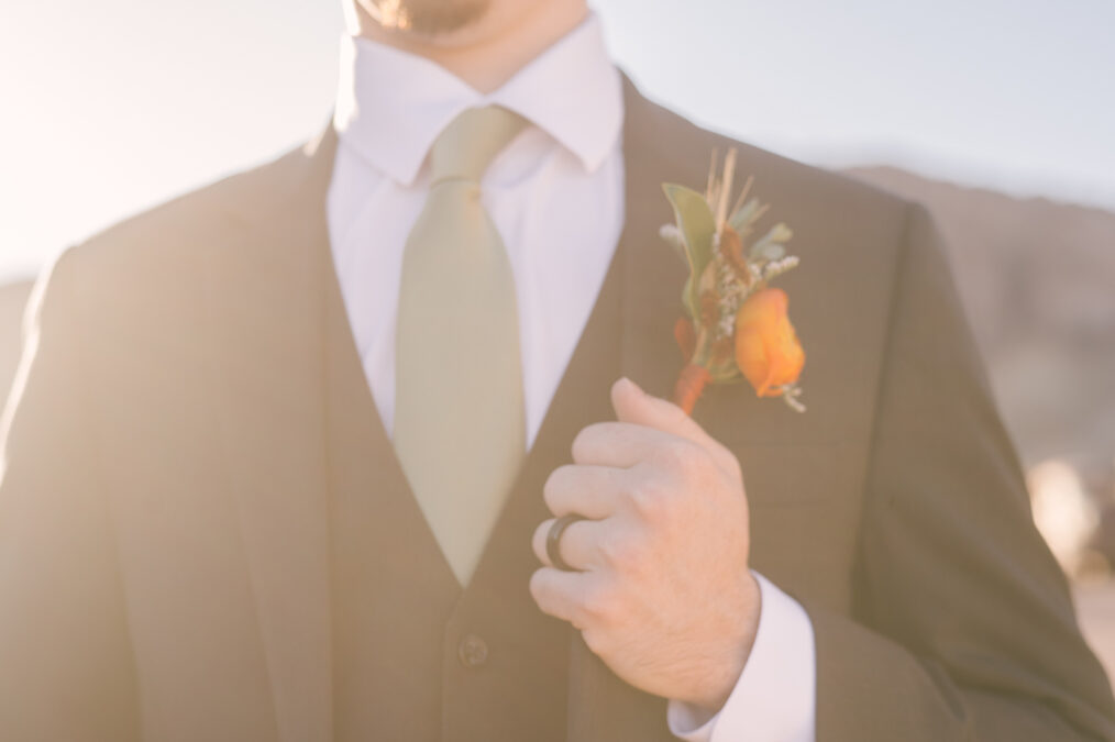 close up of groom's bout and ring 