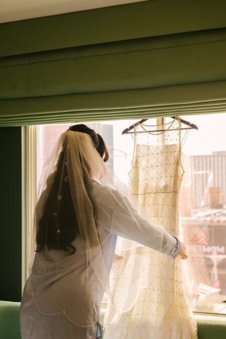 bride looking at her dress  at park mgm las vegas hotel room