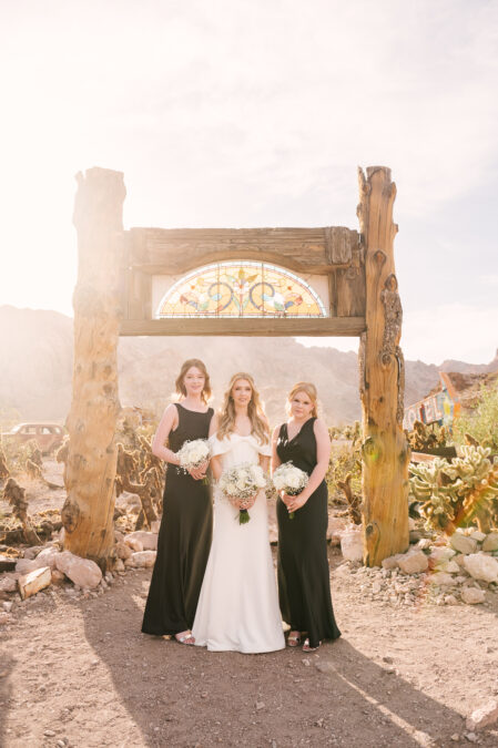 UK destination bride in front of stained glass arch in the las vegas desert with bridesmaids