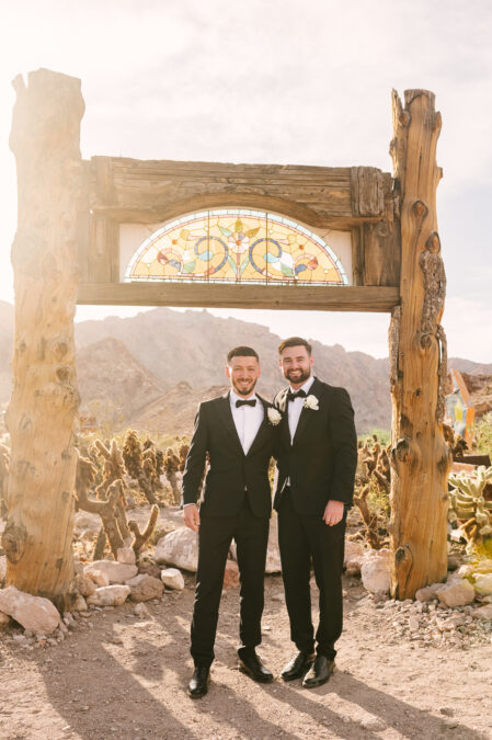 UK destination groom in front of stained glass arch in the las vegas desert with best man