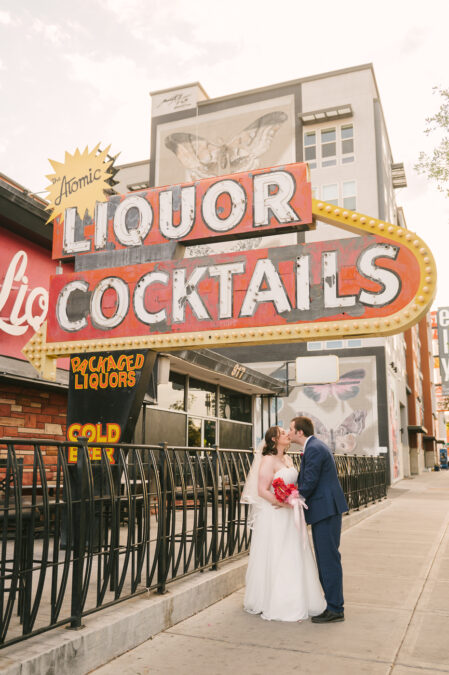 bride and groom kissing in front of atomic liquors in downtown las vegas