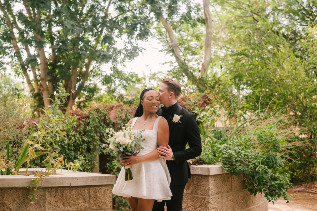 broom kissing his bride's head in sweet moment at springs preserve las vegas