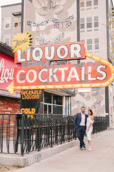 bride and groom posing in front of atomic liquor on fremont st in downtown las vegas