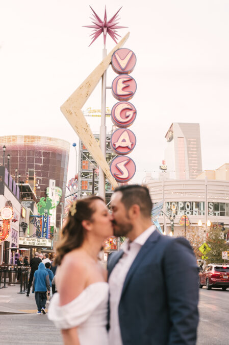 bride and groom kissing on fremont street after wedding