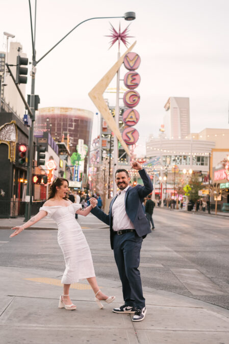 bride and groom celebrating on fremont street after wedding