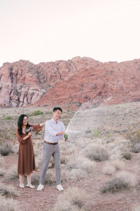 red rock canyon las vegas proposal couple spraying champagne to celebrate