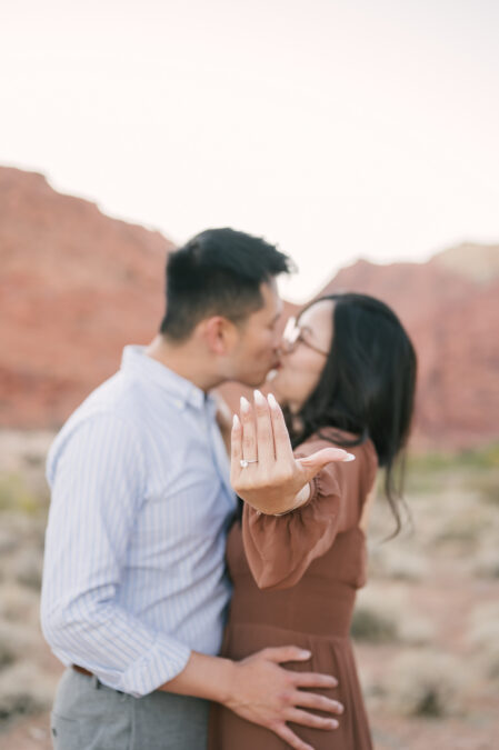las vegas red rock canyon engagement session couple kissing with focus on ring 