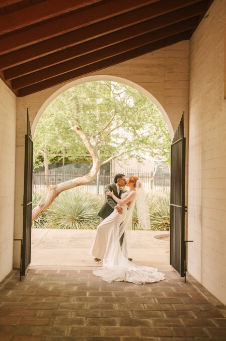 bride and groom kissing under doorway of the downtown at historic 5th street school