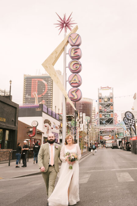 bride and groom walking down fremont street in downtown las vegas
