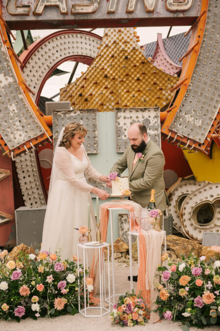 bride and groom cutting cake at the neon museum wedding