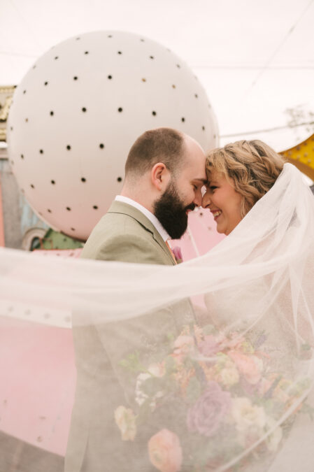 bride and groom forehead to forehead photo at neon museum