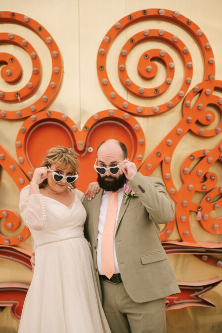 neon museum las vegas bride and groom wearing heart sunglasses