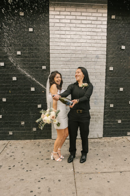 two brides spraying champagne on fremont st in downtown las vegas
